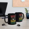 Two black mugs with a 'Best Cat Dad Ever' cat graphic on a desk.