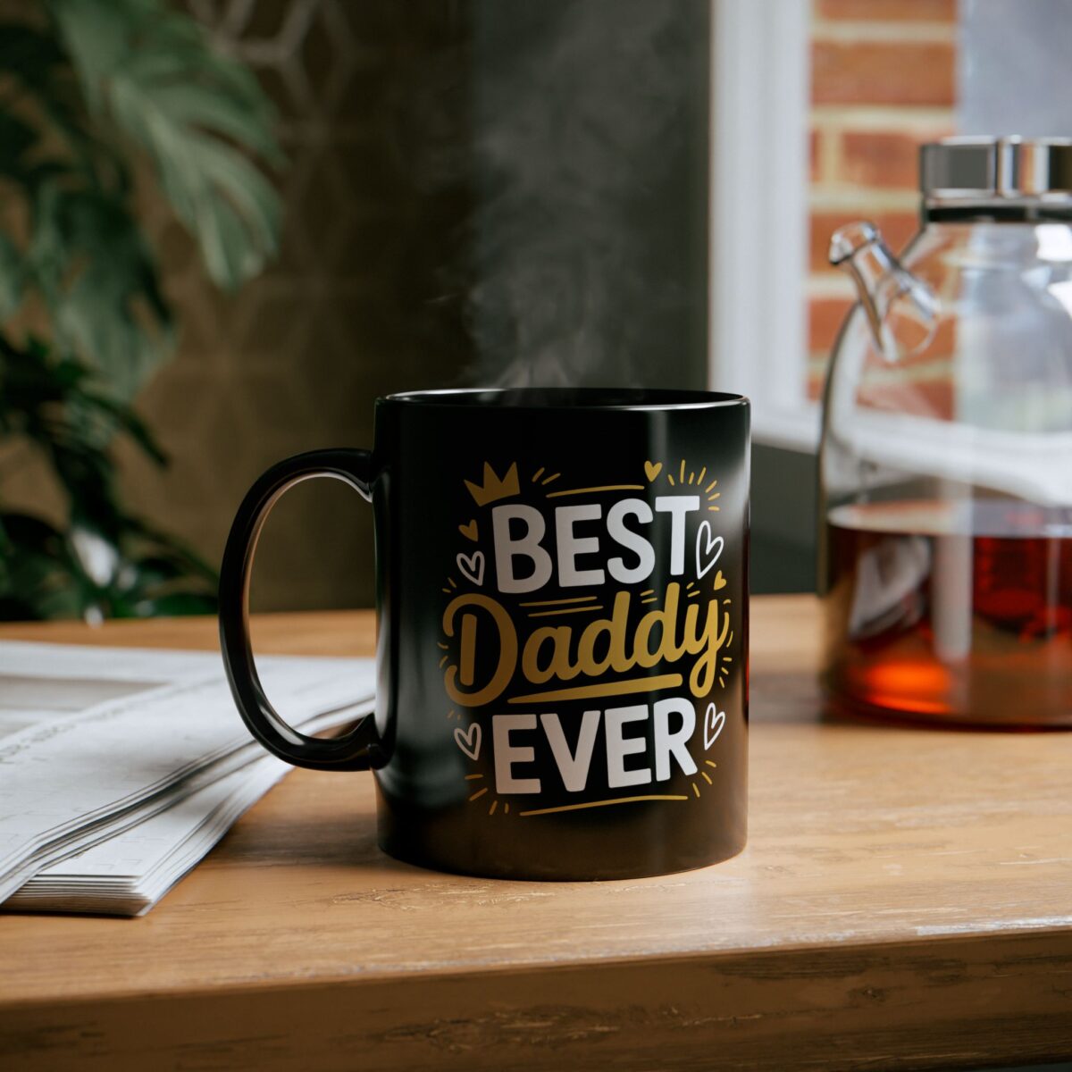 A black mug with the text "BEST Daddy EVER" in white and gold lettering with decorative hearts and a crown. Steam is rising from the mug.