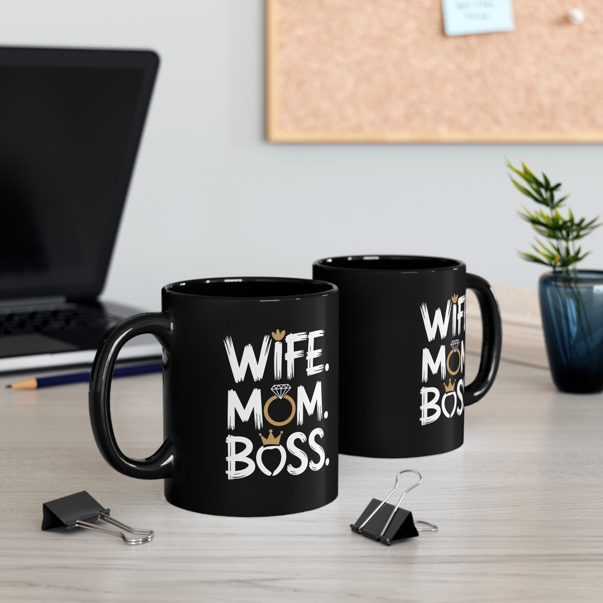 Black ceramic mug with white text reading "WIFE. MOM. BOSS." and decorative crowns and ring.