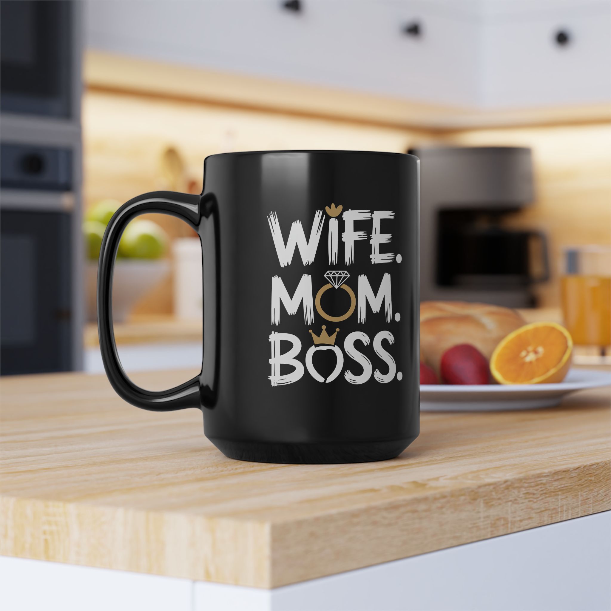 Black ceramic mug with white text "WIFE. MOM. BOSS." and crown/ring graphic details.