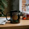 A black mug with a humorous cartoon sunflower face and the text