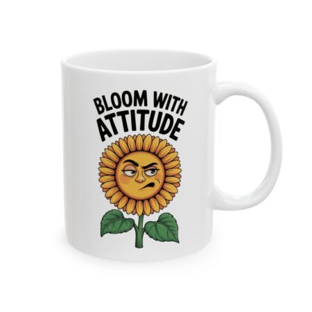 A white mug with a cartoon sunflower design. The sunflower has a grumpy, sassy expression and is captioned with "BLOOM WITH ATTITUDE" in bold black letters.