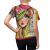 Sublimation tee with all-over print featuring a stylized abstract face with blue eyes and collage elements in vibrant colors.
