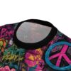 Vibrant graffiti art with peace signs in pink, blue, and yellow covers this all over print apparel, on a brick wall background.