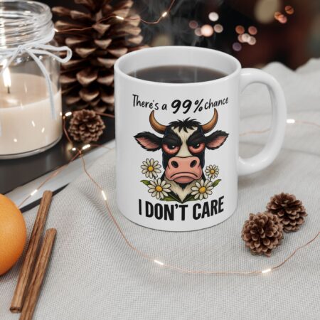 White ceramic mug with a grumpy cow illustration and "I DON'T CARE" text.