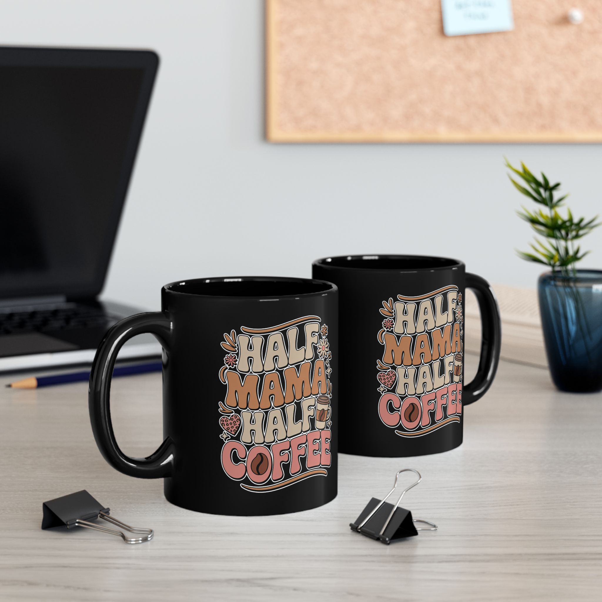Black ceramic mug with "Half Mama Half Coffee" text in retro font with hearts and coffee beans.