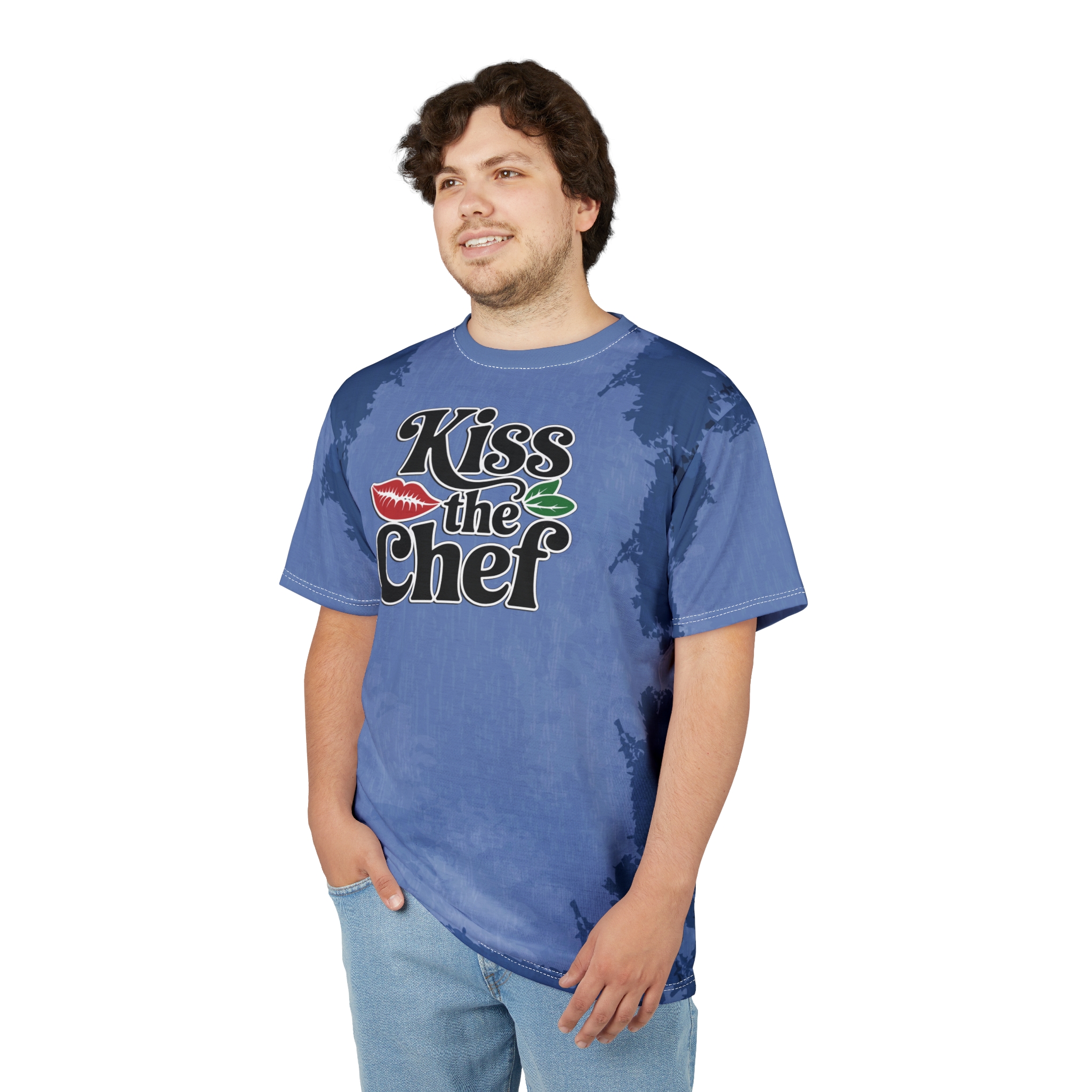 Dark blue and lighter blue tie-dye patterns cover this seamless pattern tee, featuring the words "Kiss the Chef" with a red lip and green leaves.
