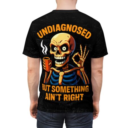 Black t-shirt, orange skeleton, holding coffee cup, giving ok sign, text 'UNDIAGNOSED BUT SOMETHING AIN'T RIGHT'.