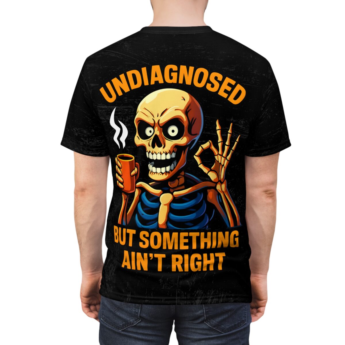 Black t-shirt, orange skeleton, holding coffee cup, giving ok sign, text 'UNDIAGNOSED BUT SOMETHING AIN'T RIGHT'.