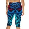 Close-up back view of a person wearing capri leggings featuring an intricate abstract design of flowing blue and red shapes.