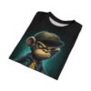 A cool monkey wearing a green cap and denim jacket covers this sublimation graphic tee, with a teal brick background.