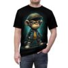 A cartoon monkey in a green cap, blue jacket, and yellow shirt is depicted on this black graphic tee shirt, with a brick wall in the background.