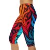 Capri leggings featuring a vibrant all-over abstract pattern of red, orange, and blue swirling leaf-like shapes on a dark background.