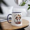 White ceramic mug with a cute sloth peeking out of a pumpkin, navy blue handle and rim.