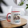 A white mug with a red handle and rim, featuring a sleeping sloth illustration and the words 