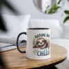 White mug with black rim and handle, featuring a cute sloth graphic and text.