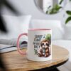 White ceramic mug with pink handle and rim, featuring a cute sloth illustration and text.