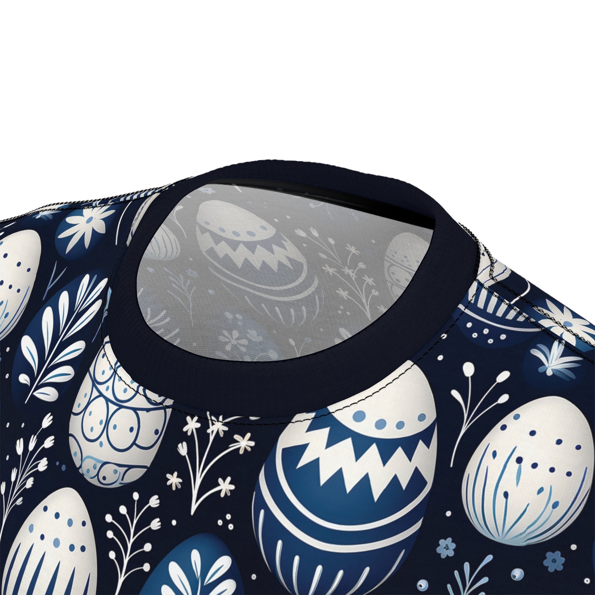 Blue and white floral and Easter egg designs cover this patterned tee shirt, with delicate sprigs and flowers scattered throughout.