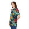 Teal, blue, yellow, and pink chrysanthemum flowers with green leaves cover this patterned tee shirt, on a white background.