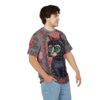 Red flowers and green leaves cover this patterned tee shirt, with a black cat centered on a geometric background.