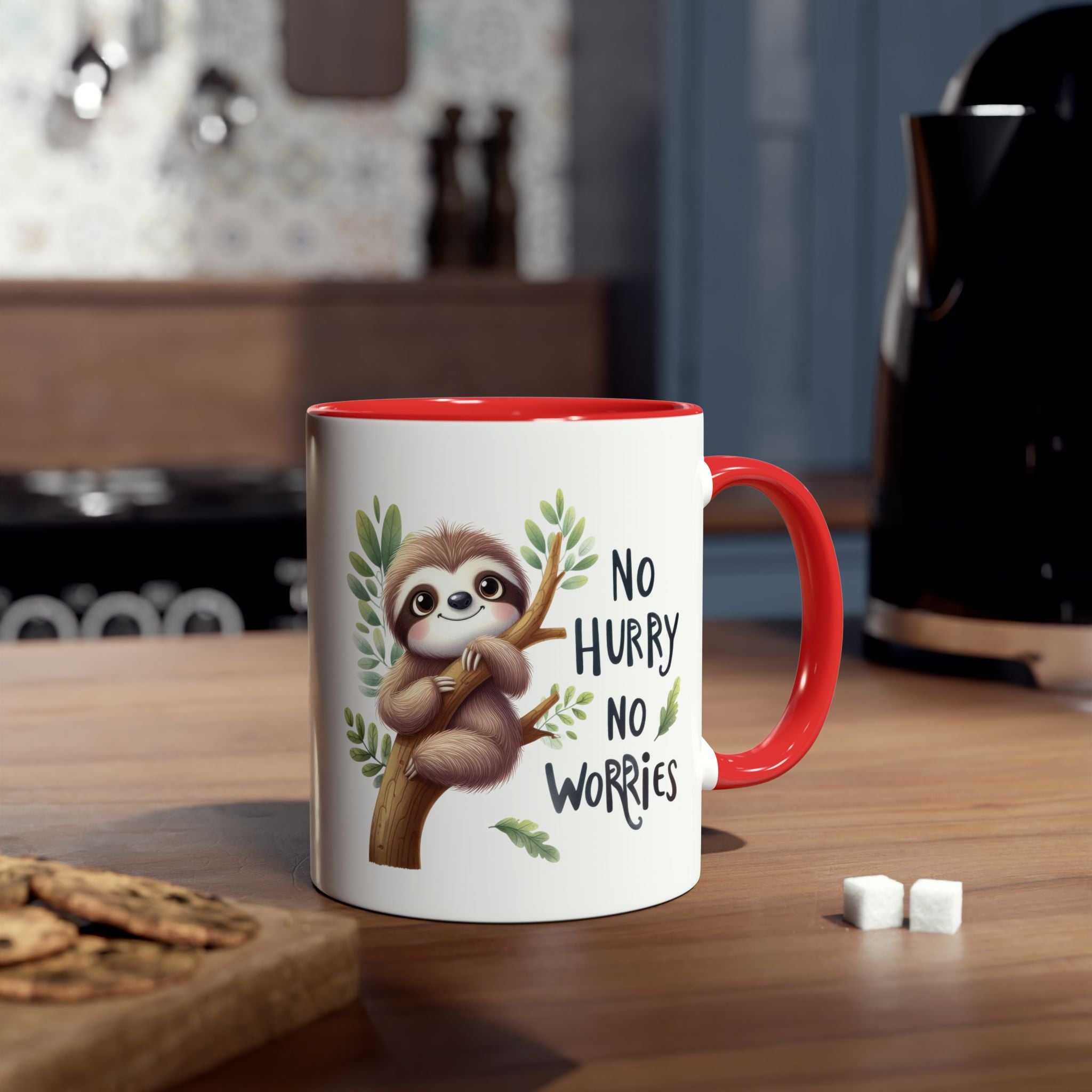 White ceramic mug with a red rim and handle, featuring a cute sloth illustration and the text "No Hurry No Worries".
