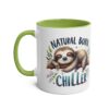 A white ceramic mug with a green handle and rim, featuring a sleeping sloth on a branch with the words 