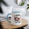 White ceramic mug with a blue handle and rim, featuring a cute sloth in a hammock with the words 