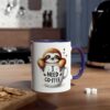 White ceramic mug with a purple handle, featuring a cartoon sloth peeking out of a coffee cup.