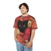 Vibrant pink, coral, and cream peonies and tulips cover this tee shirt, with a black cat peeking through the floral arrangement.