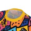 Bold abstract shapes in pink, blue, orange, and yellow cover this patterned tee shirt, with black outlines creating a graphic, energetic feel.