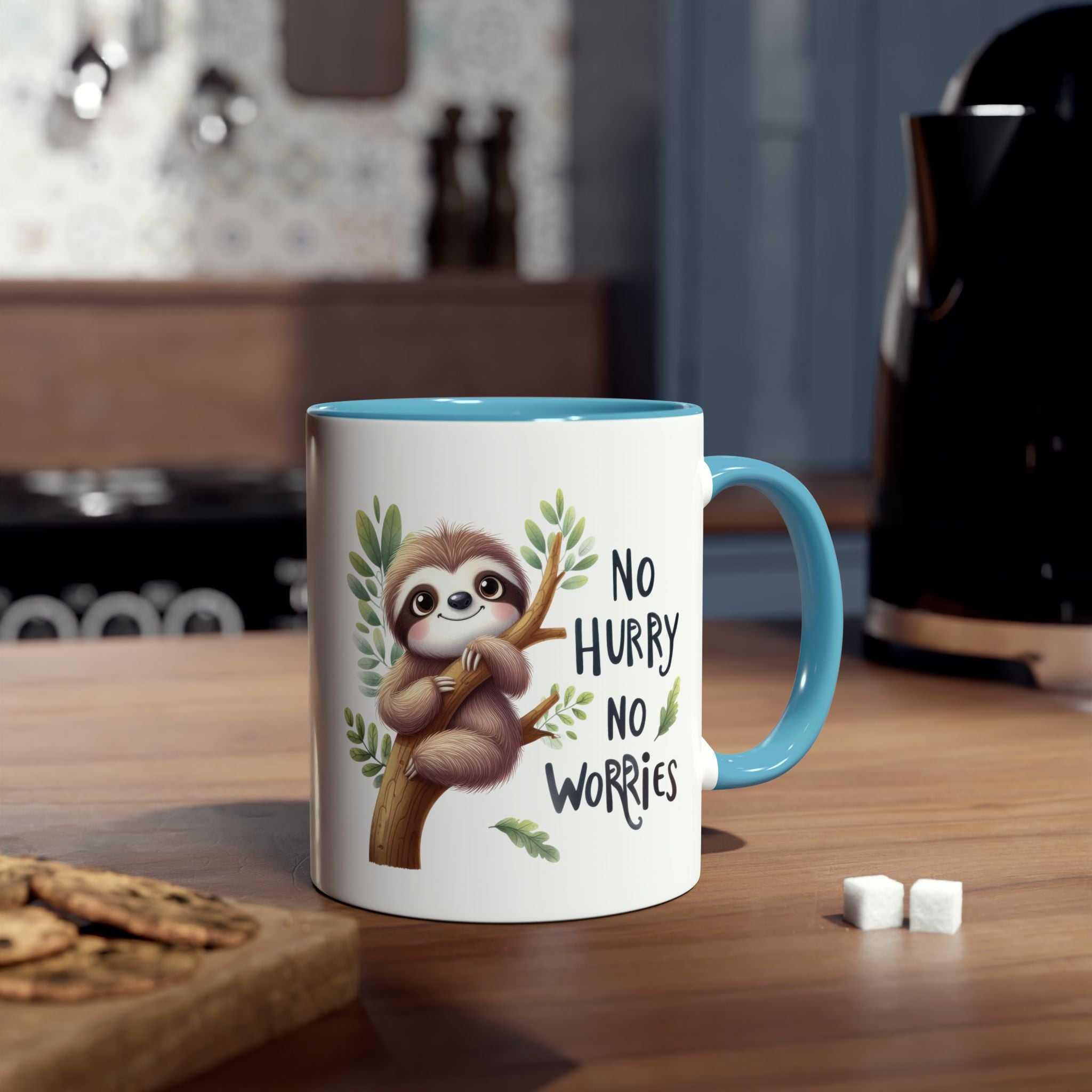 White ceramic mug with a blue interior and handle, featuring a cartoon sloth on a branch with the phrase "NO HURRY NO WORRIES".