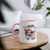 White ceramic mug with pink handle and rim, featuring a cartoon sloth in a hammock with 