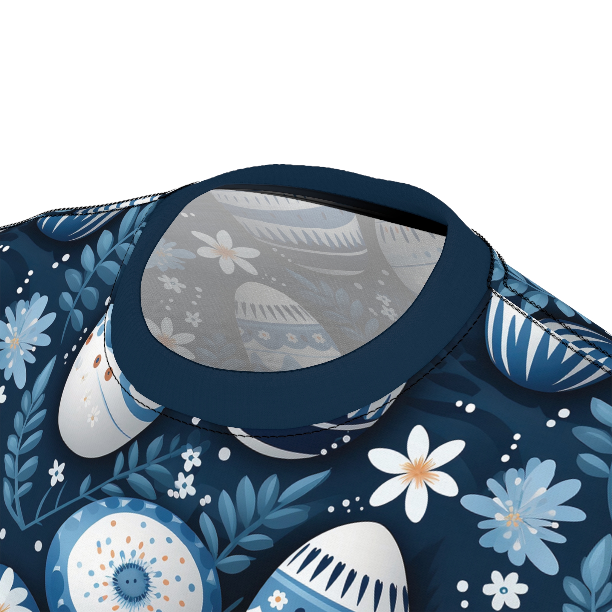 Blue and white floral patterns and Easter eggs in various blue and white hues cover this sublimation graphic tee, with a dark blue background and scattered white dots.