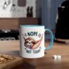 White ceramic mug with a blue handle and rim, featuring a sloth in a hammock with the words 