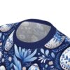 Blue and white floral patterns and ornate Easter eggs cover this seamless pattern tee, set against a deep navy background.
