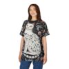 Dark floral patterns and pink flowers surround a white cat adorned with small green leaves on this patterned tee shirt.