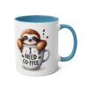 White ceramic mug with blue handle and interior, featuring a cartoon sloth peeking out of a coffee cup.