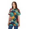 Teal, blue, yellow, and pink flowers with green leaves cover this all over print t-shirt, featuring a textured white background.