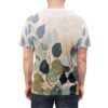 Blue, green, and tan leaves on a muted background cover this oversized full print tee, with delicate branches and watercolor textures.