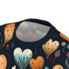 Close-up of a t-shirt with a dark blue background featuring an abstract pattern of stylized hearts in various colors including orange, yellow, blue, and white, with delicate lines and dots.
