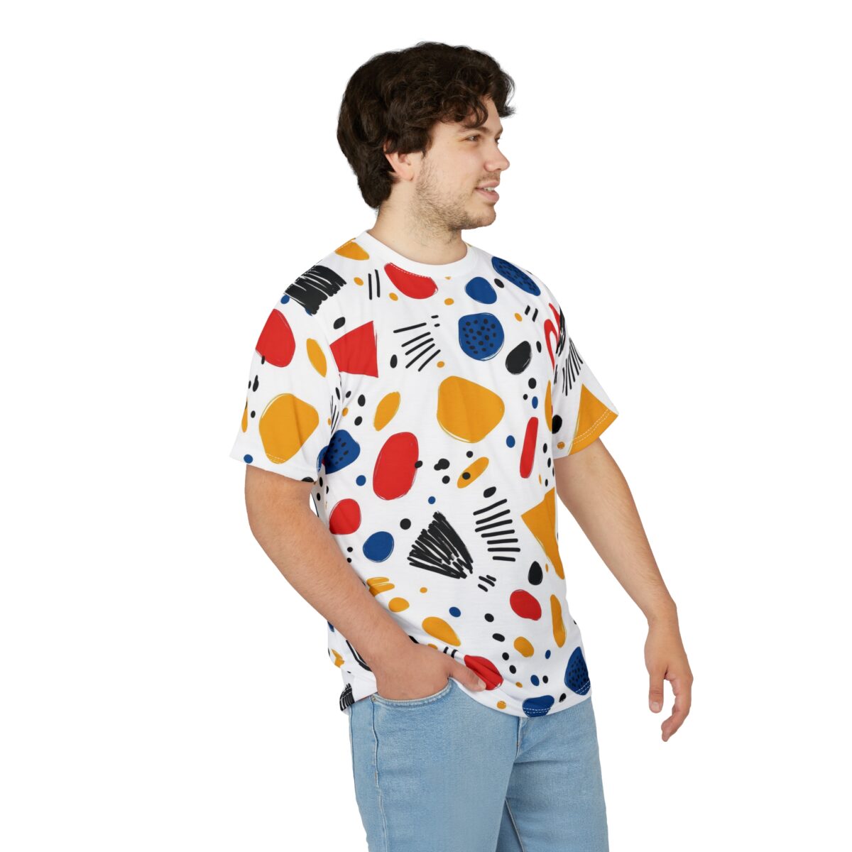 Red, yellow, blue, and black abstract shapes and scribbled lines cover this patterned tee shirt, with scattered dots and organic forms.