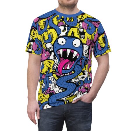 All over print t-shirt features a vibrant cartoon monster with sharp teeth and a long pink tongue surrounded by yellow and pink abstract shapes and white doodles.