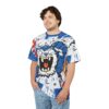 This all over print t-shirt showcases a dynamic blue and white cartoon feline graphic with bold lines and splashes of red and yellow paint.