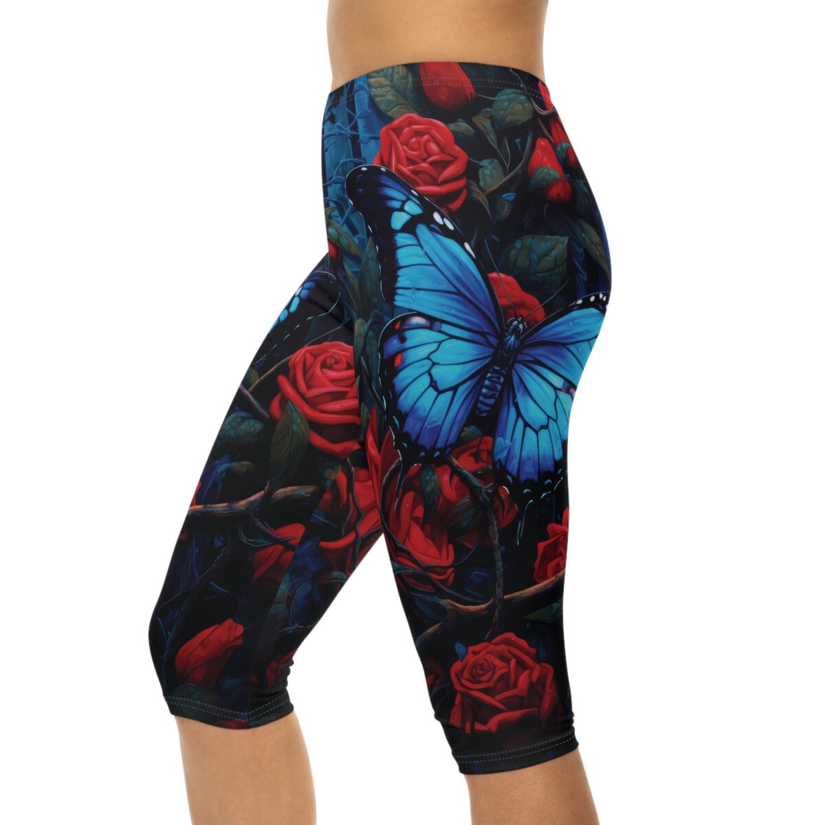 Women's capri leggings featuring a dark botanical print with vibrant red roses and a large blue butterfly.