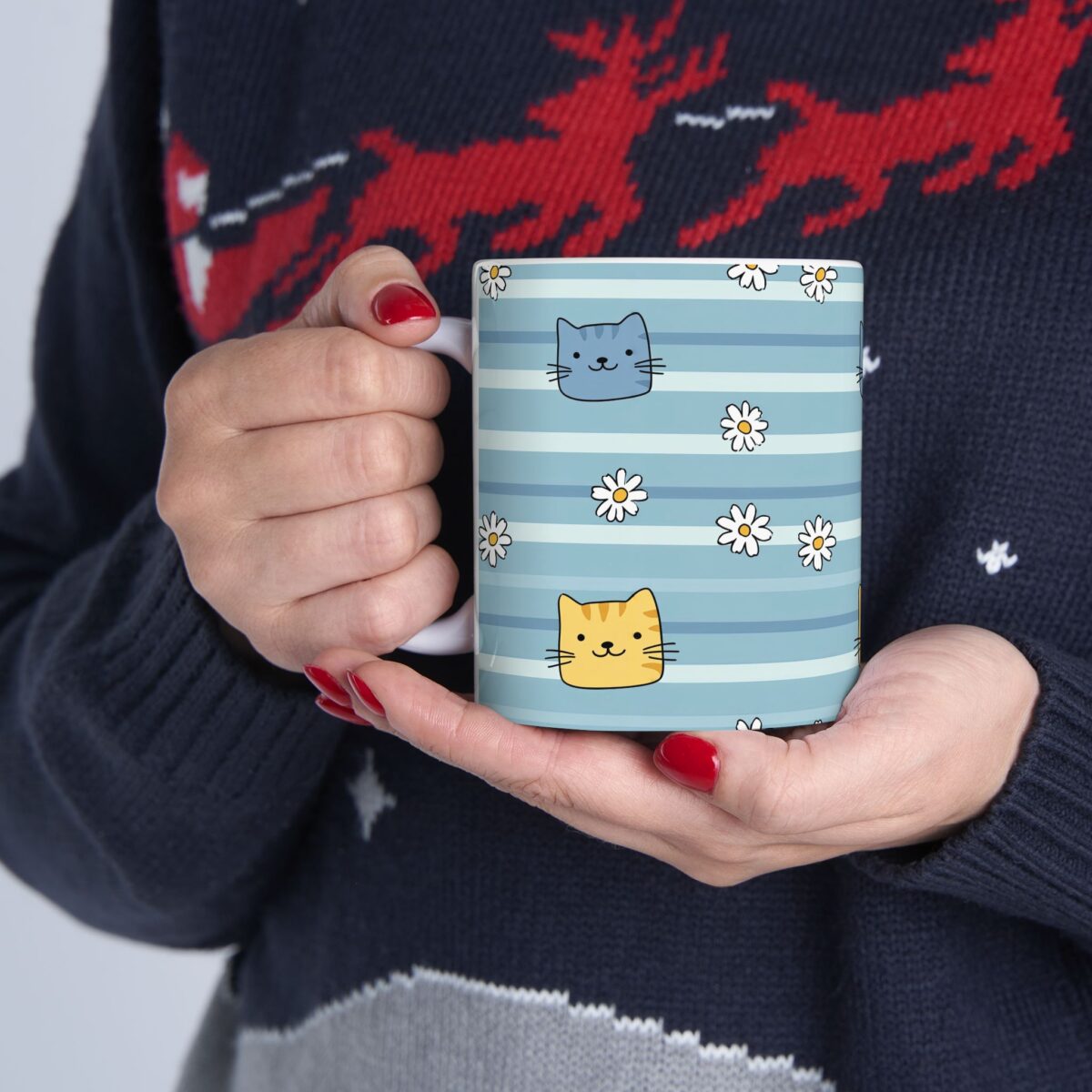A blue striped ceramic mug with cute cat and daisy illustrations.