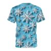 White paper-like snowflakes in various sizes scatter across a bright blue background on this oversized full print tee.