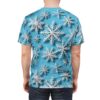 White, layered snowflakes in varying sizes cover this seamless pattern tee, set against a bright blue, softly shaded background.