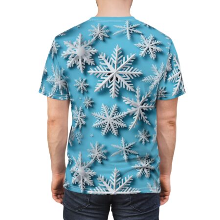 White, layered snowflakes in varying sizes cover this seamless pattern tee, set against a bright blue, softly shaded background.