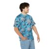 A young man wearing a blue t-shirt with a repeating pattern of white snowflakes.