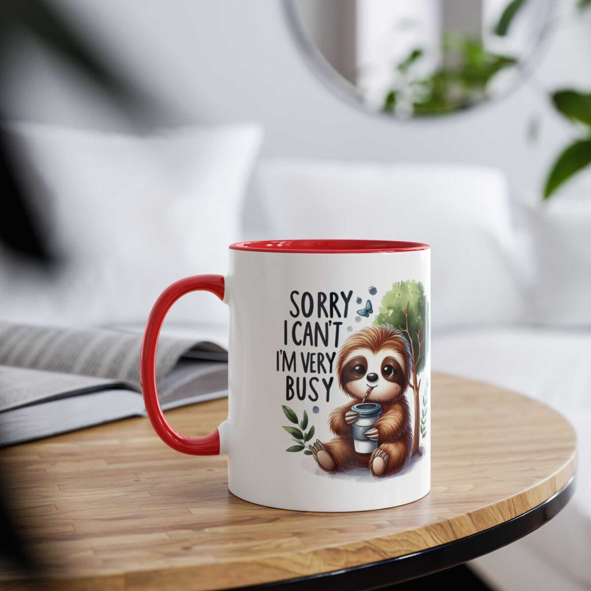 White ceramic mug with red handle and rim, featuring a cute sloth illustration with the text "SORRY I CAN'T I'M VERY BUSY".